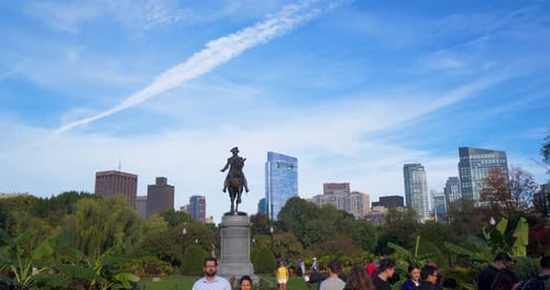 Tourists gather around george Washington statue in Boston public gardens
