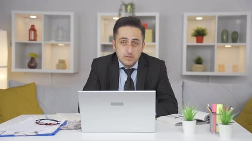 Un employé de bureau à domicile reçoit de mauvaises nouvelles de la caméra.
