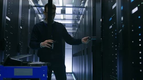 Der Servertechniker tauscht die Festplatten im offenen Schrank des Rackservers aus. Er arbeitet im Big Data Center.