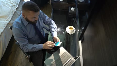 Young Businessman Working with Smartphone and Laptop by Table at Hotel Adult