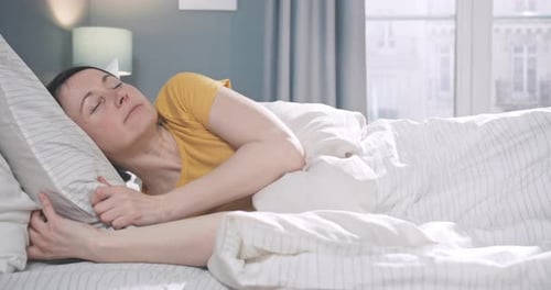 Woman Sleeping Peacefully in Bed During Daytime