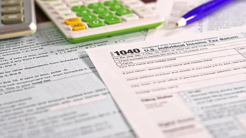 Tax form 1040 with calculators and pen close-up