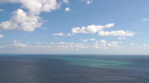 Aerial View on Azure Sea with Fluffy Cumulus Clouds Moving in Bright Sunset Sky Over Calm Sea Nature