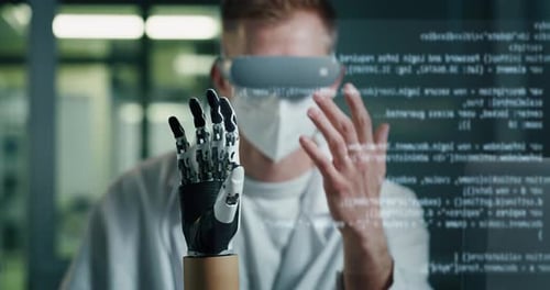 Junger Biomediziningenieur trägt eine Virtual-Reality-Brille und steuert die moderne Bionik aus der Ferne