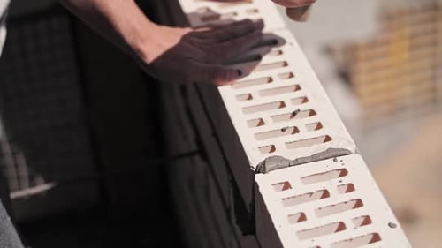 A Worker Builds a Wall of a House