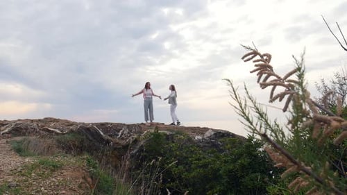 Two Young Joyful Women Standing on the Mountain