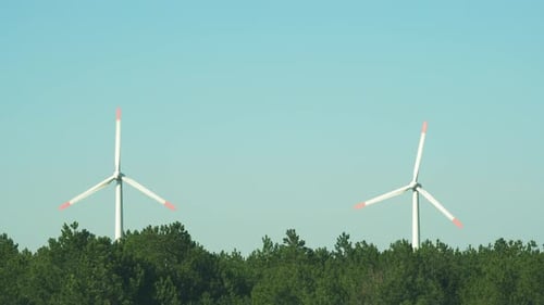 Alternative Energiequellen. Große rotierende Rotorblätter einer Windturbine vor blauem Himmel