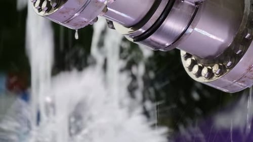 Industrial Pipes Moving Through Spraying water