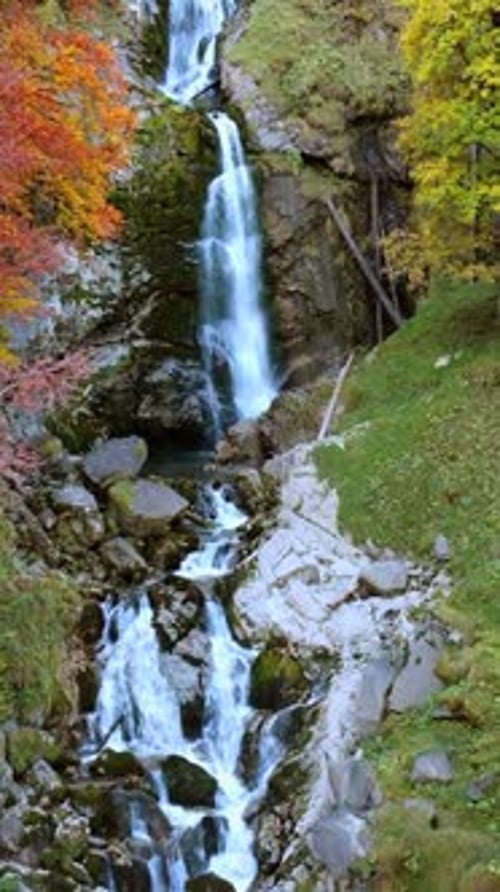 Scenic Waterfall Flowing Through Autumn Mountain Landscape