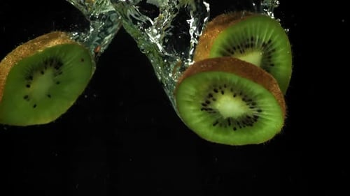 Bright Green Kiwi Fruit Slices Plunging Into Water
