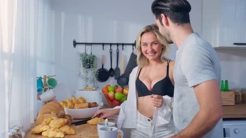 Affectionate Couple Sharing Breakfast and Hugging in Kitchen