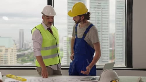 Architects Reviewing Blueprints in Modern Office