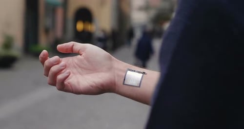 A man answers the wife who smiles and waves from the phone that appears in hologram clock futurist