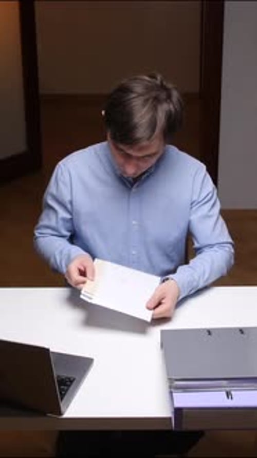 Vertical Video Office Worker Reading Documents at Desk in Modern Office
