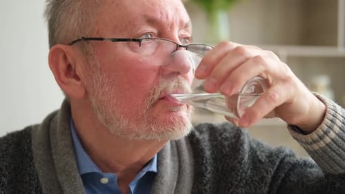 Senior Man Holding Glass Drinking Fresh Water at Home Mature Old Senior Thirsty Grandfather Takes