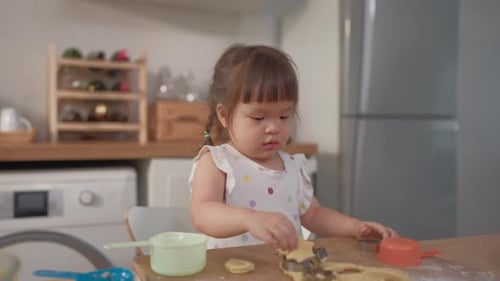 Asian young baby girl having fun with homemade baking in the kitchen.