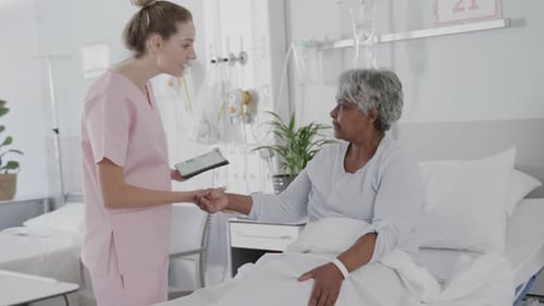 Friendly Nurse Discusses Tablet with Senior Patient in Hospital