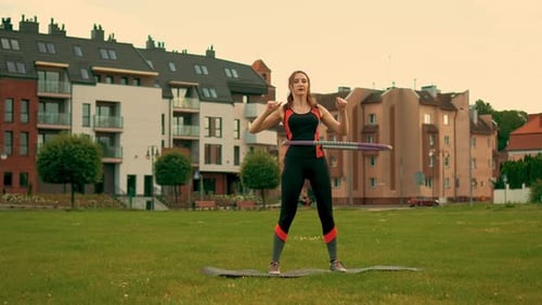 Woman Exercising with Hula Hoop in Urban Park