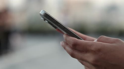 Crop View of Woman Hands Text on Smartphone Screen in Urban Environment