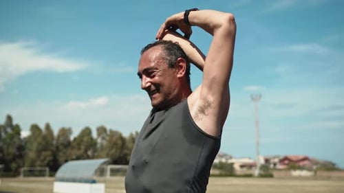 Man Stretching Arms Outdoors in Athletic Clothing