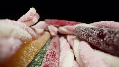I'll take a spiral pink gummy stick from the assortment of multicolored sugar-dusted gummy sticks.