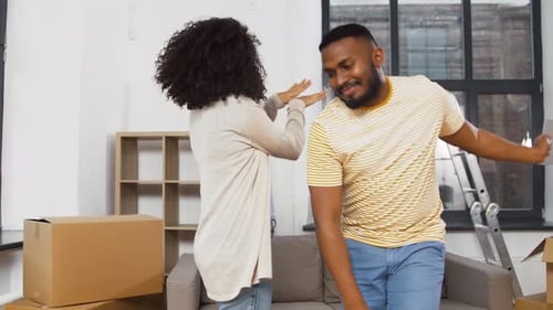 Moving, Repair and Real Estate Concept - Happy African American Couple Dancing
