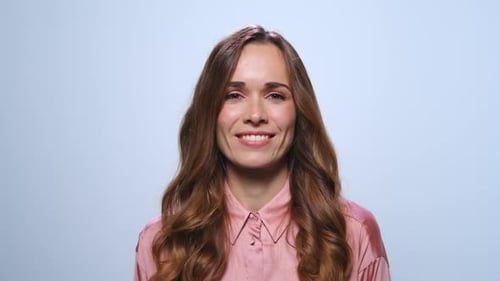 Smiling woman showing peace sign in studio setting