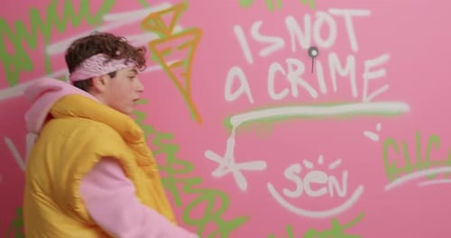 Teen in Stylish Outfit Walks Past Graffiti Wall