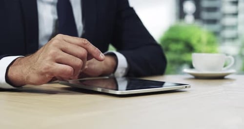 4k video footage of an unrecognizable businessman using his tablet while sitting in the office