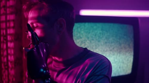 Man with Robotic Arm Smoking in Neon Room