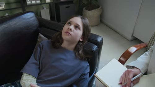 Teenager-Mädchen mit Armprothese erklärt Gefühle im Büro des Therapeuten