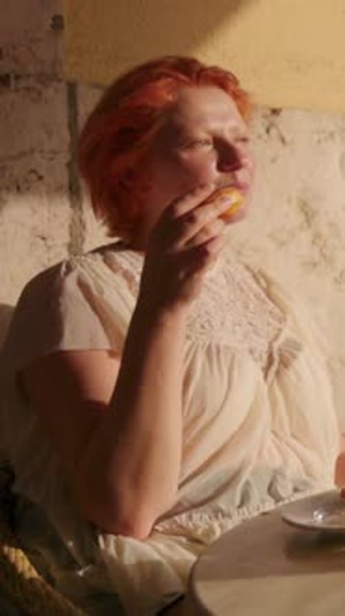 Woman Eating Sweet Treat in Golden Sunlight