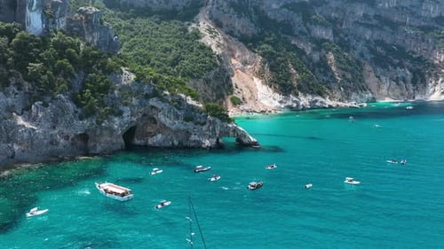 Coast as a background from top view. Drone view of a sailing yacht and boats. Aerial landscape.