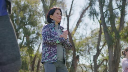 Middle Aged Woman Practicing Yoga on Group Class in the Park