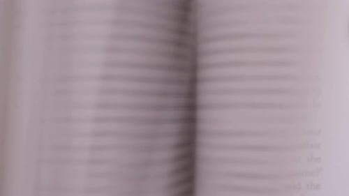 Book pages flipping quickly one after the other. black text written on the white pages. Close up of