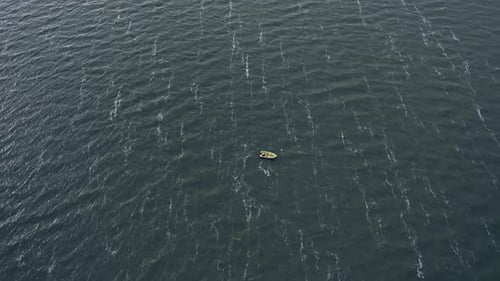 Aerial View of Lonely Motorboat on Gray Water Surface with Waves with White Foam