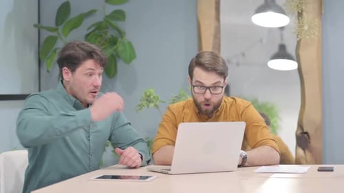Two Men Celebrate Success in Office Workplace