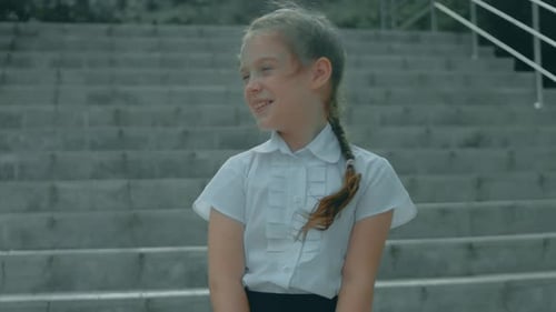 A Beautiful Happy Caucasian Schoolgirl Enjoys Rest in a Park Exuding Youthful Beauty and a Cheerful