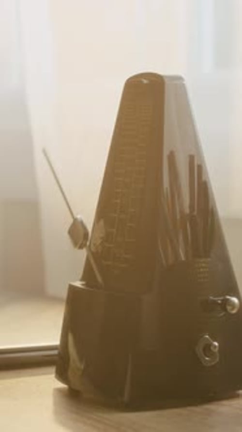 Mechanical Metronome Keeping Rhythm on Table for Music Lesson