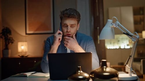 Man Talking on Phone While Working at Desk