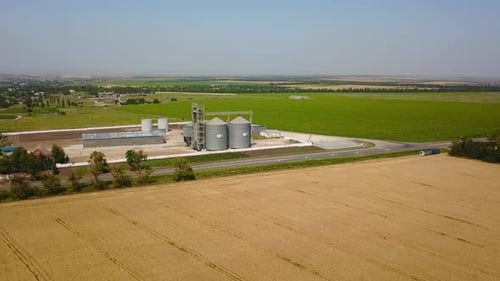 Vue aérienne d'un élévateur à grains devant un champ de blé, drone quadricoptère, caméra volant autour de la farine ou de l'huile