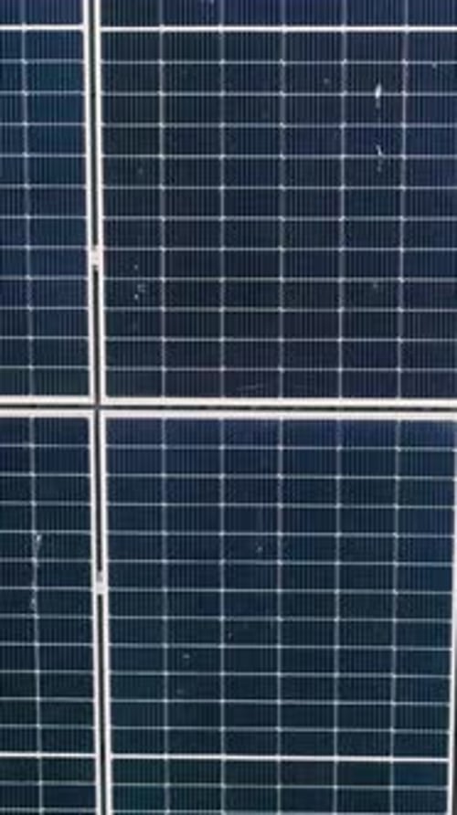 Vertikale Bildschirmnahaufnahme der Oberfläche von blauen Photovoltaik-Solarmodulen, die darauf montiert sind