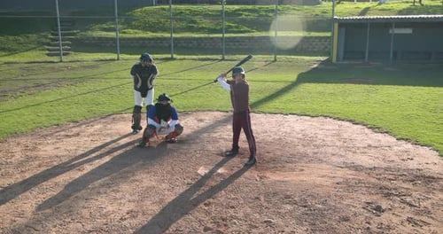 Playing baseball, batter running to first base while catcher and umpire watch