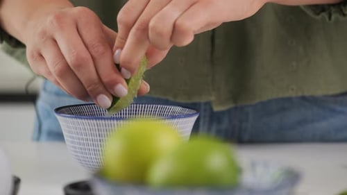 Close-up squeezing fresh lime juice by hand.