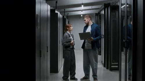 IT Technicians Discuss Data on Laptop in Server Room