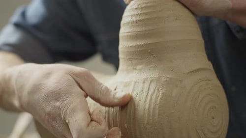 Closeup of the Hands of a Ceramist Making Strokes in a Clay Product