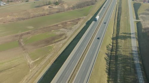 Cars And Truck Driving Through The Highway Along The Countryside Road In Summer. - aerial shot