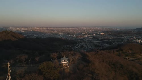 Asiatische Pagode auf dem Berggipfel mit Stadt und Meer in der Ferne