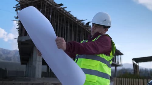 Engineer Examining Blueprints at Construction Site