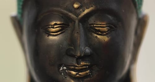 Zoom in on a Buddha statue from close up. Spirituality, meditation and third eye opening concept. 4k